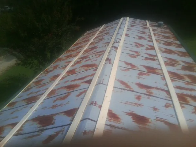 Rusted metal roof panels with new wood purlins before replacement — Storm Damage Roof Repair in Pine Hall by Roofing Brothers