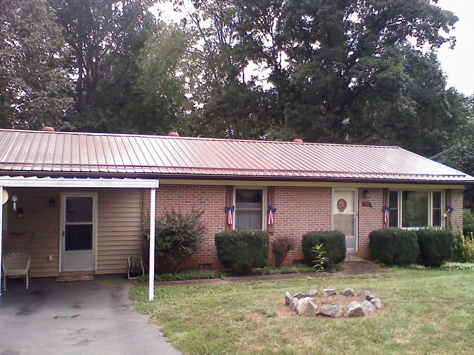 Bronze metal roof and carport on a brick ranch home — Roof Repair work by our crew in Pine Hall